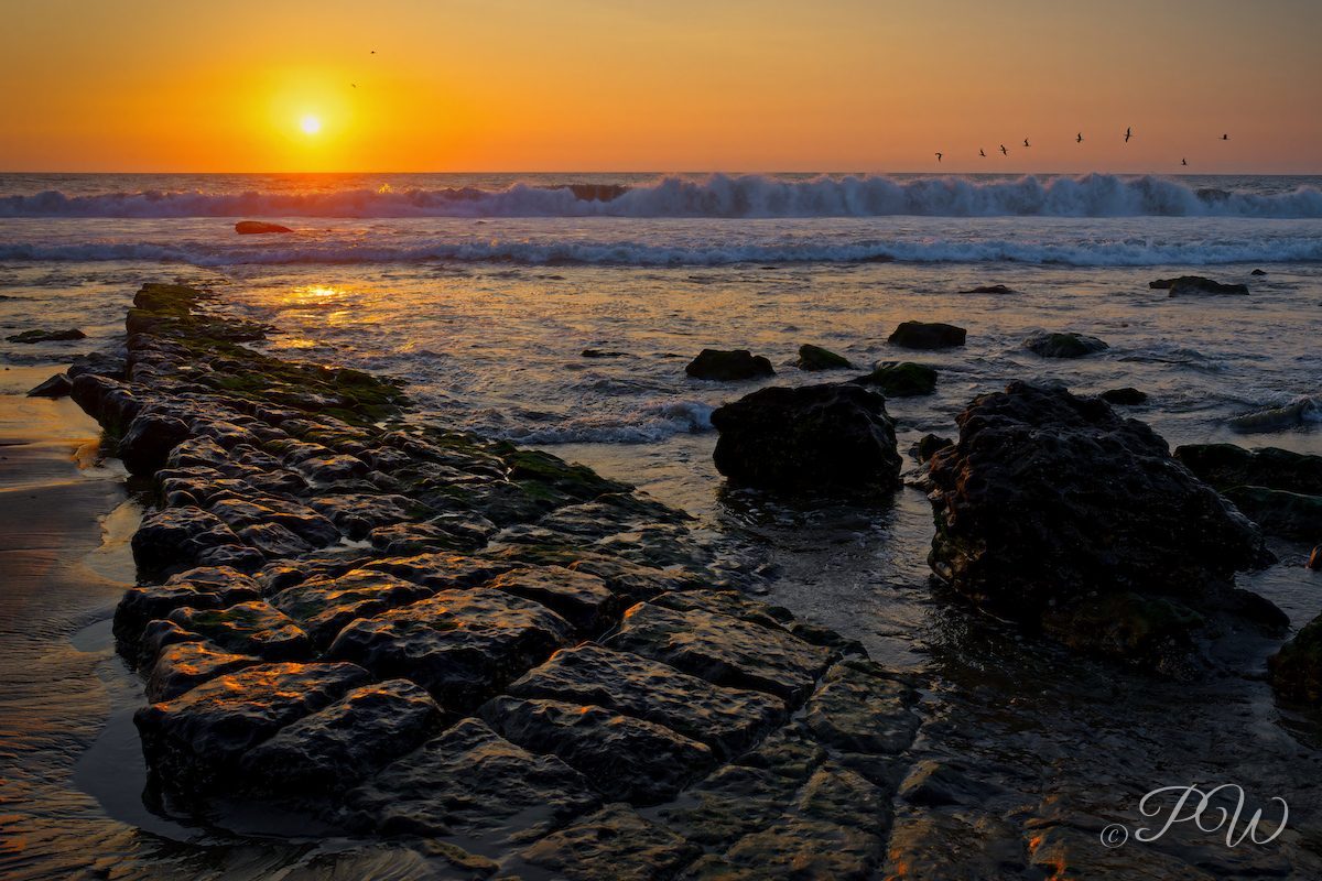 Sunset over the rocky shore at Máncora, Peru